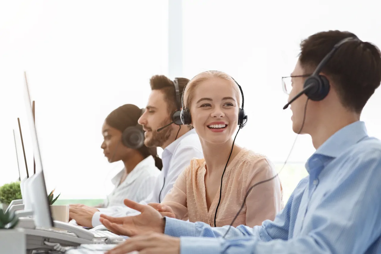 four customer service workers with headsets on