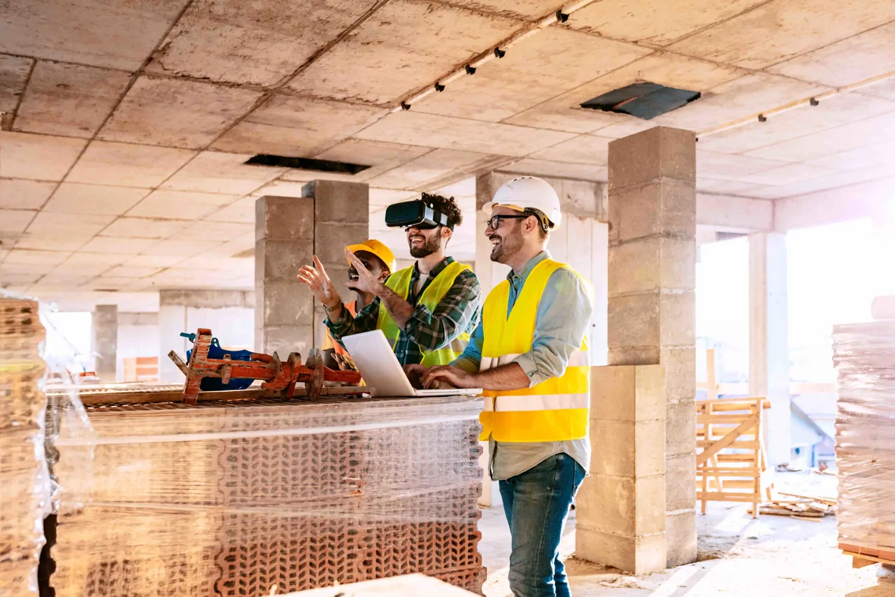 Three construction workers on a building site using VR to review the site designs