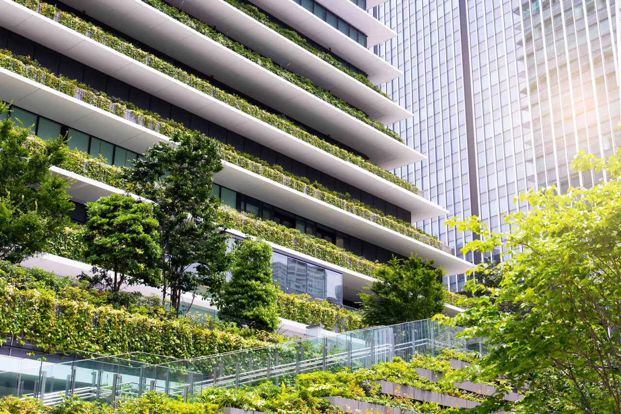 High rise building with lots of green trees and plants