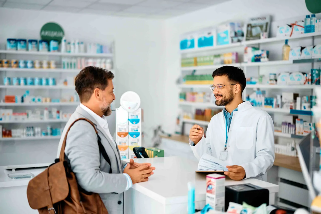 A pharmacist talking to a man at the counter